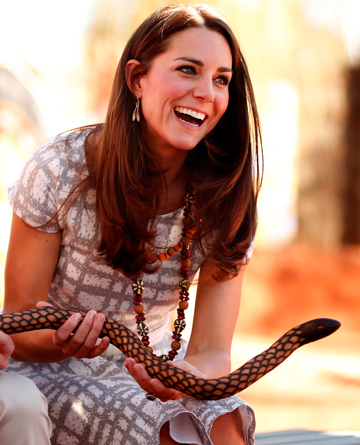 Kate laughs as she holds a carved wooden snake.