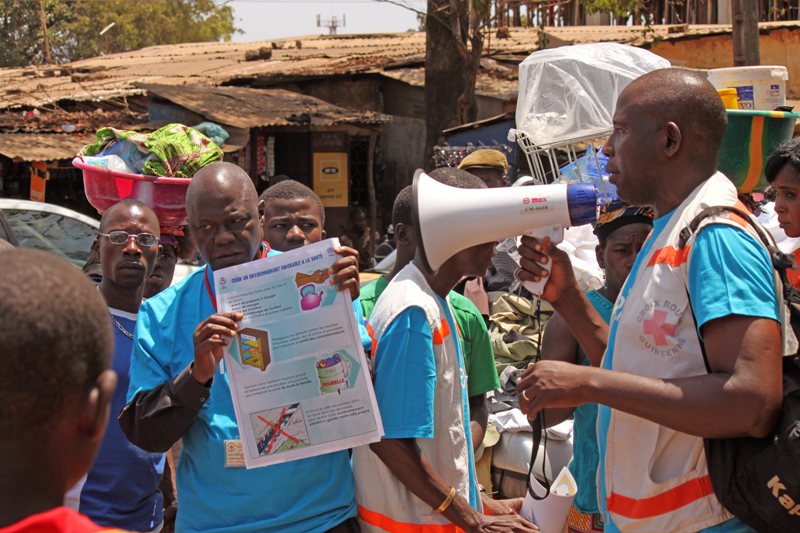 Health workers teach people about the Ebola virus and how to prevent infection, in Conakry, Guinea, Monday, March 31, 2014. Health authorities in Guinea are facing an "unprecedented epidemic" of Ebola, the international aid group Doctors Without Borders warned Monday as the death toll from the disease that causes severe bleeding reached 78. (AP Photo/ Youssouf Bah).