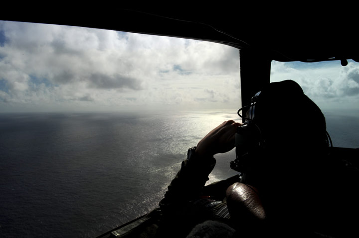 Pilot and aircraft captain, Flight Lieutenant Timothy McAlevey of the Royal New Zealand Airforce (RNZAF) P-3K2-Orion aircraft, helps to look for objects during the search for missing Malaysia Airlines flight MH370 in flight over the Indian Ocean on April 13, 2014 off the coast of Perth, Australia. 