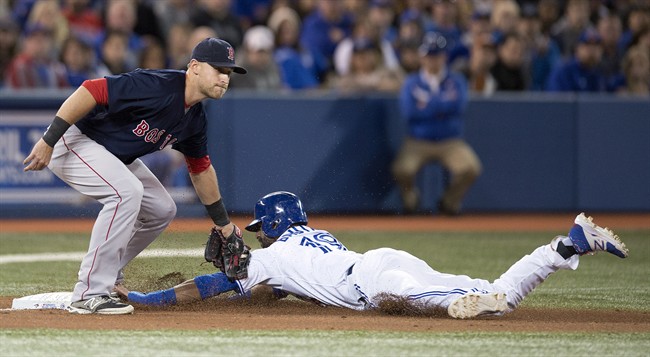 Boston Red Sox third baseman Will Middlebrooks (left) catches Toronto Blue Jays Jose Bautista stealing third during fourth inning AL action in Toronto on Friday April 25, 2014. THE CANADIAN PRESS/Frank Gunn.