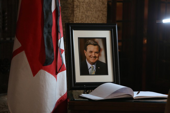A book of condolences and a photograph of former Finance Minister Jim Flaherty is placed on a table in the lobby of House of Commons on Parliament Hill in Ottawa on Friday, April 11, 2014. Flaherty died suddenly Thursday of an apparent heart attack. He was 64. 