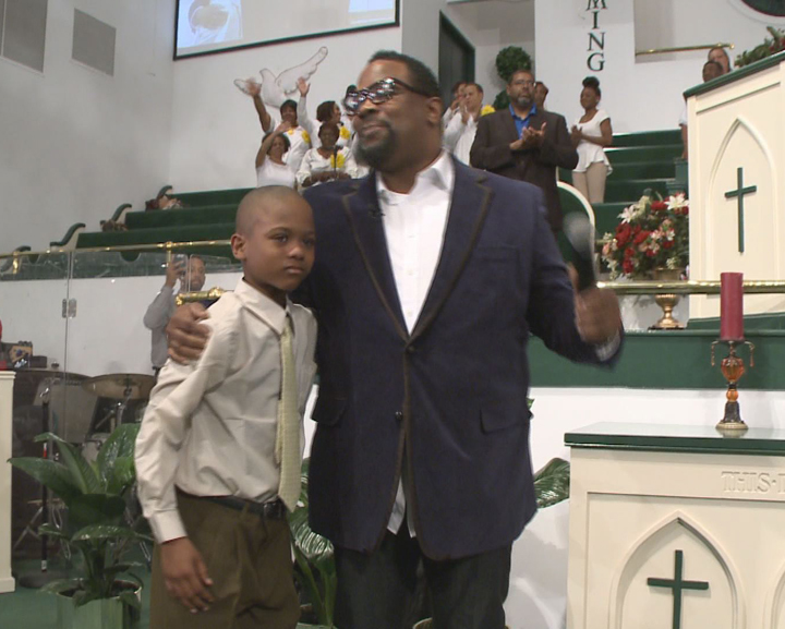 In an April 10, 2014, image provided by WXIA-TV, 9-year-old Willie Myrick is embraced by Grammy Award-winning gospel singer Hezekiah Walker in front of the congregation at Mt. Carmel Baptist Church in Atlanta. Police say Myrick was abducted from his driveway but was released after singing the gospel song "Every Praise" until the abductor released him.