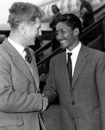 This picture taken 27 October 1957 shows Sherpa Tensing Norgay (R) being welcomed at London airport by Brigadier Sir John Hunt.