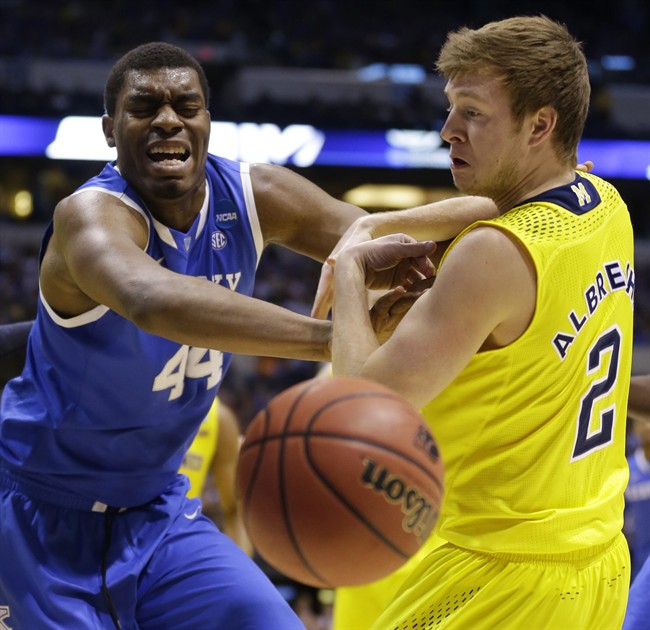 Kentucky's Dakari Johnson (44) and Michigan's Spike Albrecht (2) go after a loose ball during the first half of an NCAA Midwest Regional final college basketball tournament game Sunday, March 30, 2014, in Indianapolis.
