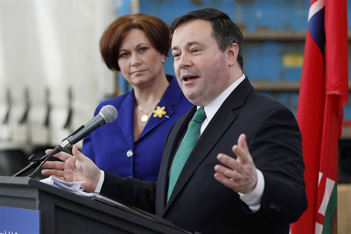 Federal Employment Minister Jason Kenney responds to media questions in Winnipeg on Wednesday as Manitoba Jobs and the Economy Minister Theresa Oswald listens.