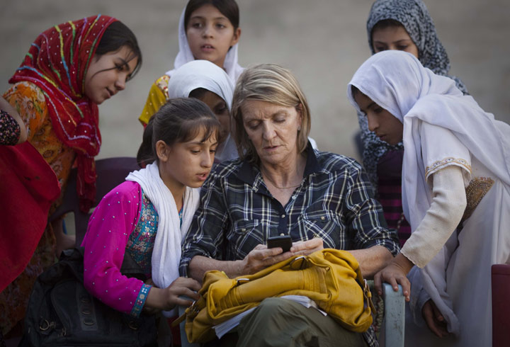 In this Saturday, Oct 1, 2011 photo, AP Special Regional Correspondent for Afghanistan and Pakistan Kathy Gannon sits with girls at a school in Kandahar, Afghanistan.