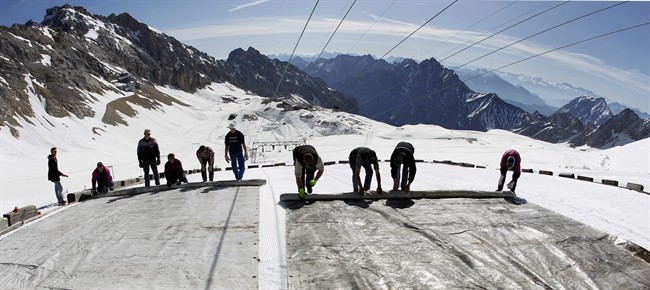 In this May 10, 2011 file photo, workers cover the glacier with oversized plastic sheets on the peak of Germany's highest mountain Zugspitze (2962 meters) near Garmisch-Partenkirchen, southern Germany. The sheets are meant to keep the glacier from melting during the summer months. 