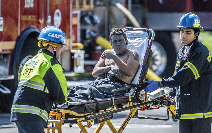 An injured worker is moved toward a waiting ambulance after an explosion was reported at a business in La Habra, Calif.