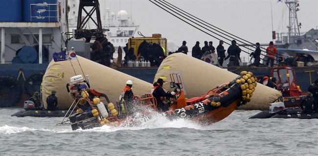 Searchers and divers look for people believed to have been trapped in the sunken ferry boat Sewol near the buoys which were installed to mark the vessel in the water off the southern coast near Jindo, south of Seoul, South Korea, Tuesday, April 22, 2014. 