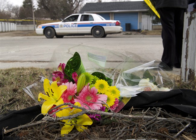 Makeshift memorial at police tape line near the scene of a multiple fatal stabbing in northwest Calgary, Alberta on Tuesday, April 15, 2014. Calgary police say the son of one of their own is a suspect in the worst mass murder in the city's history, a bloody and baffling attack on a group of university students at a house party. THE CANADIAN PRESS/Larry MacDougal.