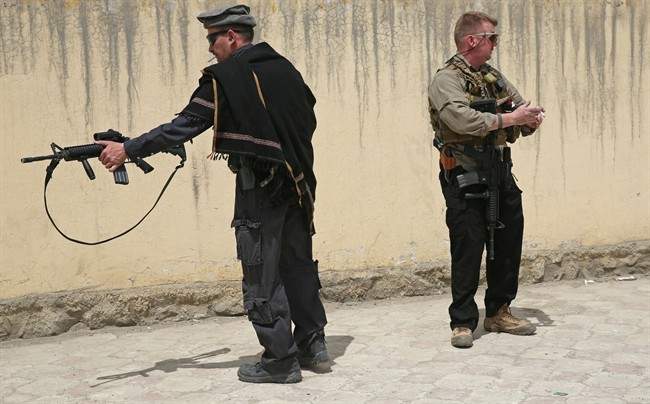 Foreign security guards stand near the main gate of Cure International Hospital in Kabul, Afghanistan, Thursday, April 24, 2014. The U.S. embassy in Afghanistan says three American doctors have been killed at by an Afghan security guard who opened fire at a hospital in Kabul. The shooting at Cure International Hospital in western Kabul was the latest attack on foreign civilians in the Afghan capital this year. (AP Photo/Massoud Hossaini).