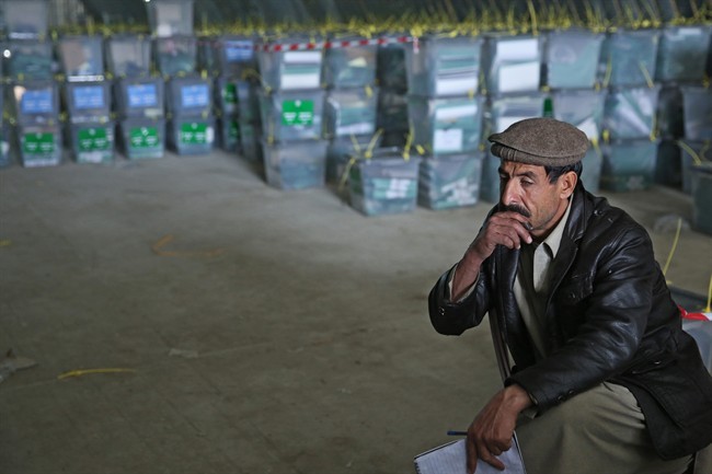 An Afghan election worker rests while working with ballot boxes at a warehouse of the Independent Elections Commission warehouse in Kabul, Afghanistan, Sunday, April 6, 2014. 