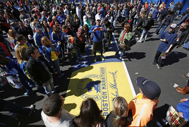 A large crowd gathers to pose for photos at the Boston Marathon finish line, one day before the race, Sunday, April 20, 2014, in Boston.
