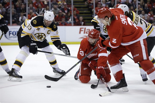Detroit Red Wings defenseman Brendan Smith (2) controls the puck in front of teammate Drew Miller (20) and Boston Bruins defenseman Zdeno Chara (33) of the Czech Republic, during the second period of Game 3 of a first-round NHL hockey playoff series in Detroit, Tuesday, April 22, 2014.