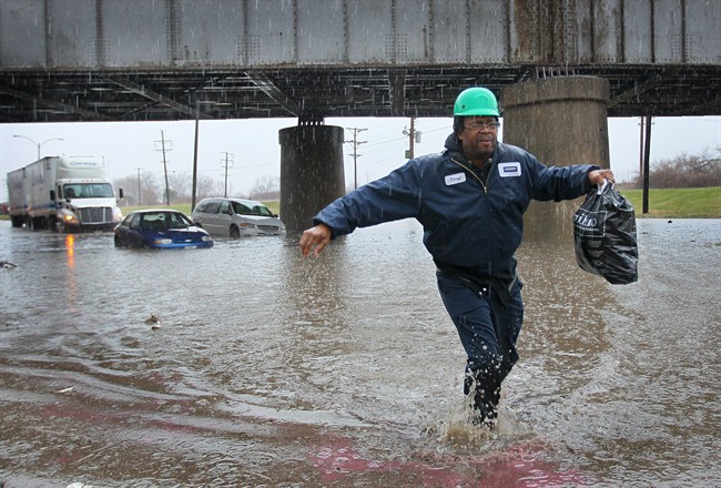 A man walks away from his minivan stuck in floodwater in St. Louis on Wednesday, April 2, 2014. Three vehicles became stuck in the high water caused by a downpour. 