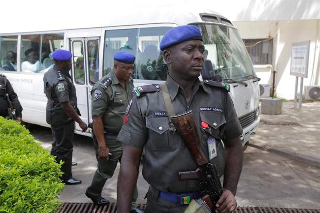 Security men stand guard in front of a bus conveying All progressives Congress opposition governors after visiting victims of at the Accident and Emergency unit of Asokoro hospital where injured people from Monday's explosion at a bus station are receiving treatment in Abuja, Nigeria, Wednesday, April 16, 2014.