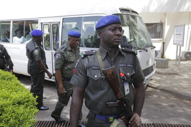 Security men stand guard in front of a bus conveying All progressives Congress opposition governors after visiting victims of at the Accident and Emergency unit of Asokoro hospital where injured people from Monday's explosion at a bus station are receiving treatment in Abuja, Nigeria, Wednesday, April 16, 2014.
