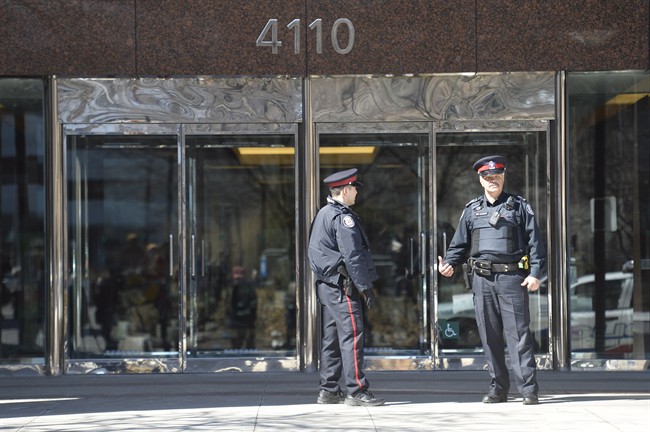 Toronto police stand outside an office building in the city's north end follwoing a stabbing.