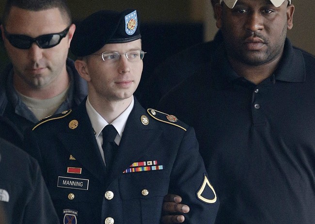In this Aug. 20, 2013 file photo,Chelsea Manning, who then went by the name Bradley Manning, is escorted to a security vehicle outside a courthouse in Fort Meade, Md.