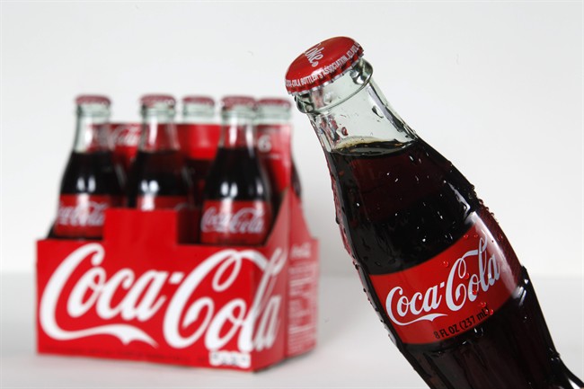This Oct. 15, 2012 photo shows eight ounce bottles of Coca Cola arranged for a photo in Surfside, Fla. Coca-Cola Co. reports quarterly financial results before the market opens on Tuesday, April 15, 2014. (AP Photo/Wilfredo Lee)