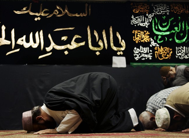 In this Feb. 1, 2012, file photo, Imam Malik Sakhawat Hussain, left, leads prayers at the Al-Mahdi Foundation in New York.