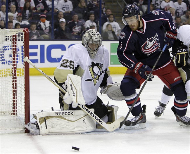 Pittsburgh Penguins' Marc-Andre Fleury, left, makes a save against Columbus Blue Jackets' Jack Skille during the second period of Game 6 of a first-round NHL playoff hockey series Monday, April 28, 2014, in Columbus, Ohio.