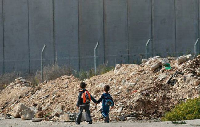 Young Palestinian boys walk home from school on what was once a major road from Israel into the West Bank.