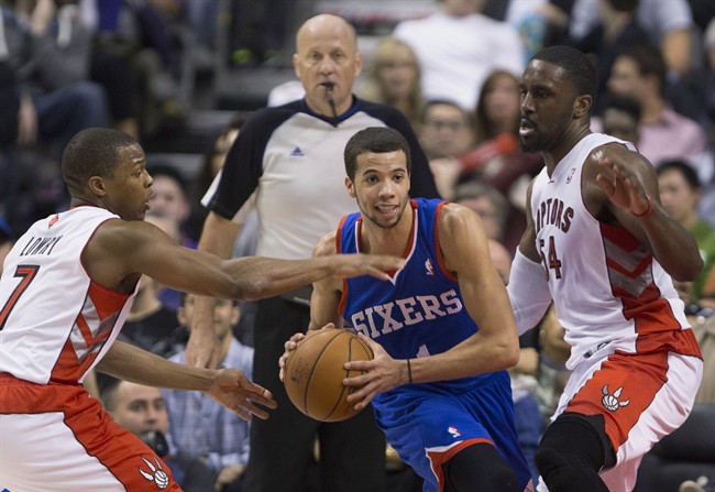 Philadelphia 76ers guard Michael Carter-Williams (1) is closely guarded by Toronto Raptors guard Kyle Lowry (7), left, and Raptors forward Patrick Patterson (54) during first half NBA action in Toronto on Wednesday, April 9, 2014. THE CANADIAN PRESS/Peter Power.