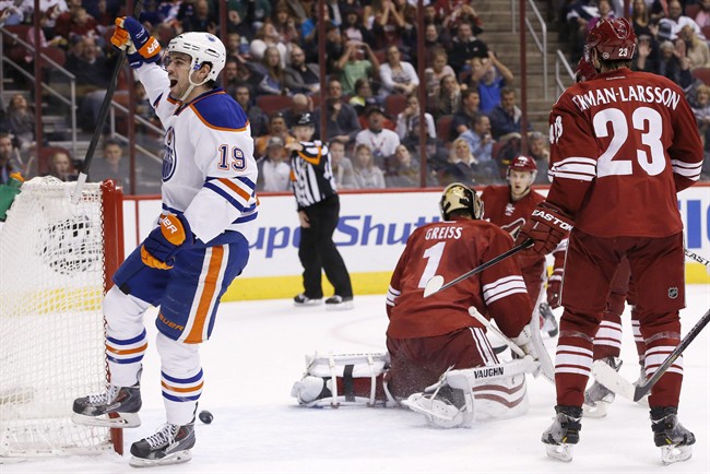 Edmonton Oilers' Justin Schultz (19) celebrates his goal against Phoenix Coyotes' Thomas Greiss (1), of Germany, as Coyotes' Oliver Ekman-Larsson (23), of Sweden, and Lauri Korpikoski, rear, of Finland, watch during the first period of an NHL hockey game, Friday, April 4, 2014, in Glendale, Ariz.