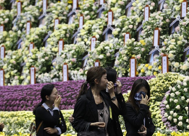 People weep as they pay tribute to the victims of the sunken ferry Sewol at a group memorial altar in Ansan, south of Seoul, South Korea, Tuesday, April 29, 2014. 
