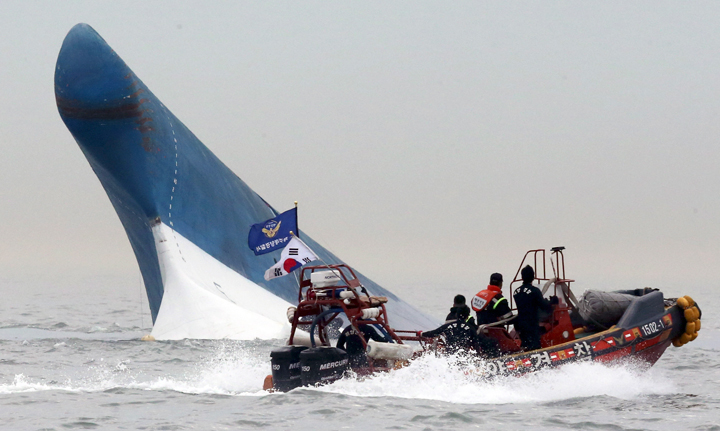 South Korean coast guard officers try to rescue passengers from a ferry sinking in the water off the southern coast near Jindo, south of Seoul, South Korea, Wednesday, April 16, 2014. 