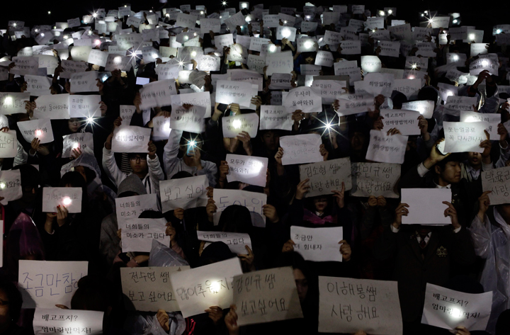 Danwon High School students hold papers with messages such as "come back," "miss you," "love you" and "don't loose your hope" for their friends who are missing after Wednesday's ferry disaster during a candlelight vigil at the school yard in Ansan, South Korea, Thursday, April 17, 2014. Strong currents, rain and bad visibility hampered an increasingly anxious search Thursday for 287 passengers, many thought to be high school students, still missing more than a day after their ferry flipped onto its side and sank in cold waters off the southern coast of South Korea.