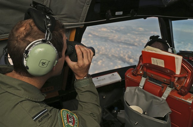 A Royal Australian Air Force P-3 Orion uses binoculars during the search for missing Malaysian Airlines flight MH370 in southern Indian Ocean, Australia. 