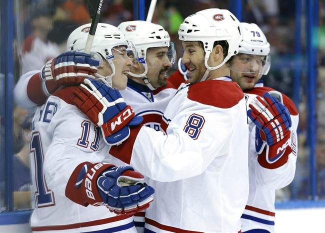 Montreal Canadiens center Tomas Plekanec, second from left, of the Czech Republic, celebrates with teammates, including Brendan Gallagher, left, Brandon Prust, second from right, and Andrei Markov, right, after scoring against the Tampa Bay Lightning during the first period of Game 1 of a first-round NHL hockey playoff series on Wednesday, April 16, 2014, in Tampa, Fla. 