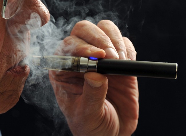 In this Jan. 17, 2014 file photo, a smoker demonstrates an e-cigarette in Wichita Falls, Texas. 