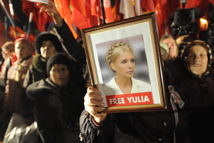 A protester holds up a photo of the imprisoned former Ukrainian Prime Minister, Yulia Tymoshenko, as supporters of the Ukrainian Opposition party take part in a rally outside the Central Elections Commission building in Kyiv, Ukraine, Monday, Nov. 12, 2012. 