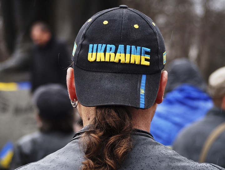 A man in a hat with the word: "Ukraine" listens to a speaker during a pro-Ukraine rally in Luhansk, 30 kilometers (20 miles) west of the Russian border, Ukraine, Sunday, April 13, 2014. 