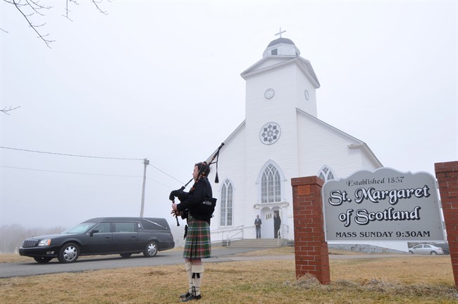Piper Kenneth MacKenzie greets the funeral procession for the late Alistair MacLeod at St. Margaret of Scotland Church in Broad Cove, N.S., on Saturday, April 26, 2014. 