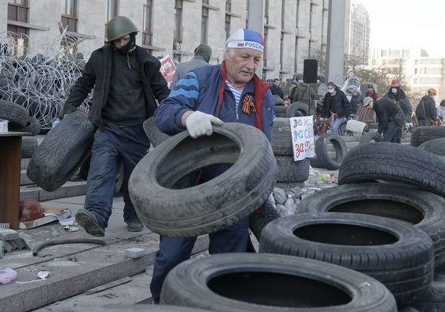 Activists prepare a barricade in front of the regional administration building in Donetsk, Ukraine, Tuesday, April 8, 2014. 
