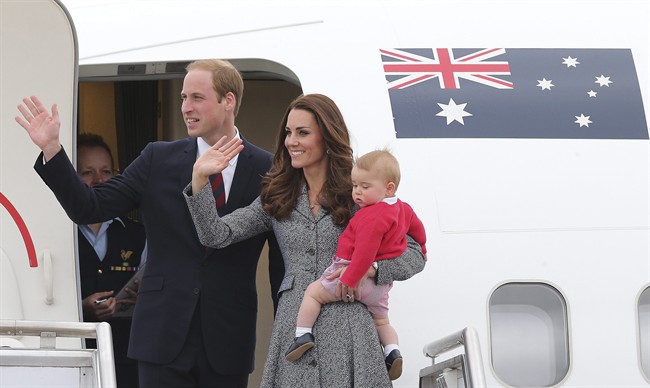 Prince William and Kate, the Duchess of Cambridge, with son Prince George, stand atop of the stairs and wave good bye as they board their flight in Canberra, Australia, Friday, April 25, 2014. 