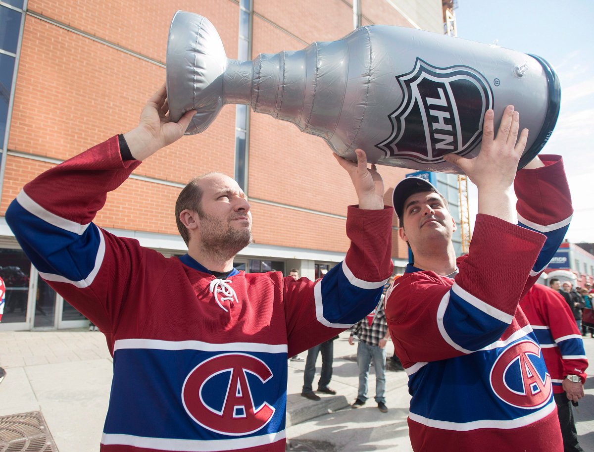 Montreal Canadiens' fans John Tzintzis, left, and Adam Gellert hold up a fake Stanley Cup .