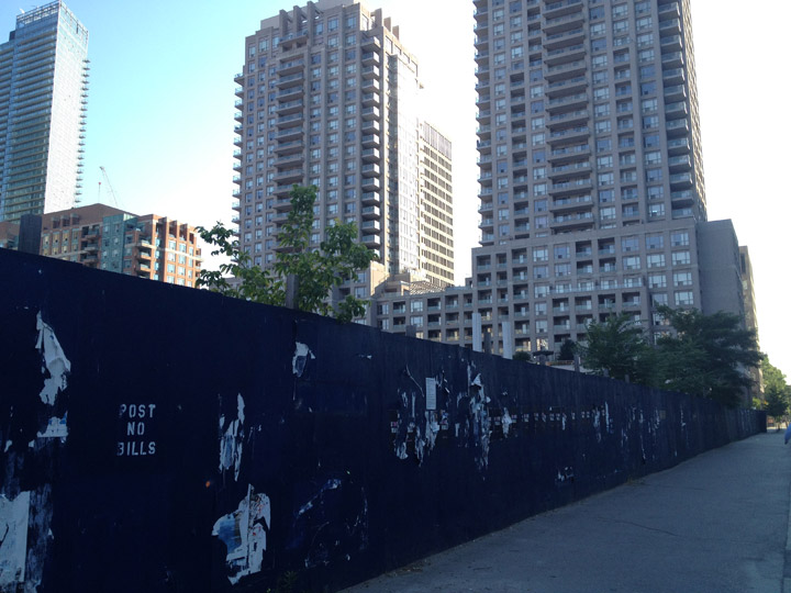 Boards surround an empty plot of land at 11 Wellesley in Toronto on July 13, 2012.