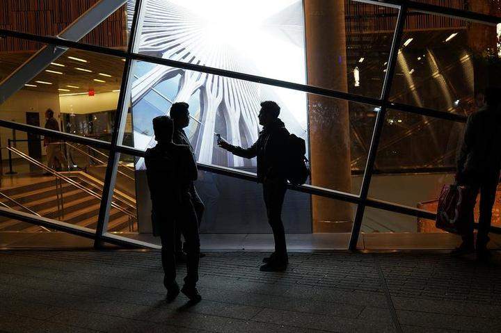 People walk the grounds at the Ground Zero memorial site after authorities recently took down gates and opened the plaza to the public on May 19, 2014 in New York City.