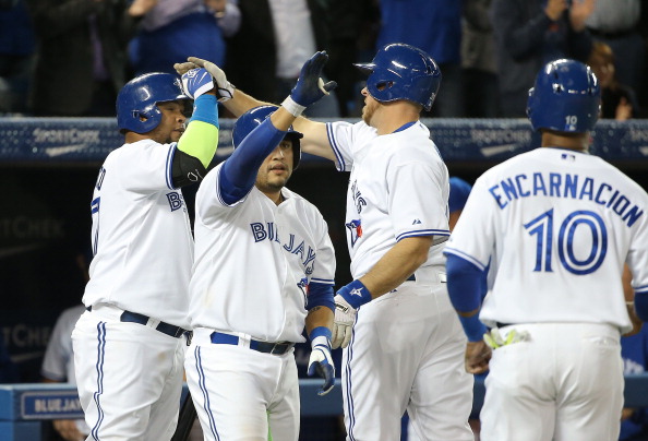 Erik Kratz #31 of the Toronto Blue Jays is congratulated by Juan Francisco #47, Dioner Navarro #30 and Edwin Encarnacion #10 after hitting a two-run home run in the seventh inning during MLB game action against the Philadelphia Phillies on May 7, 2014 at Rogers Centre in Toronto, Ontario, Canada. (Photo by Tom Szczerbowski/Getty Images).