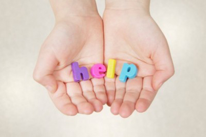 Child hands holding letters spelling the word h-e-l-p
