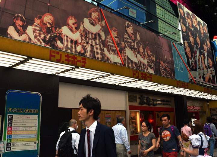 Pedestrians pass before the AKB48 theatre in Tokyo on May 26, 2014. Two teenage members of Japanese girl group AKB48 were in hospital after being attacked on May 25 by a man wielding a saw.