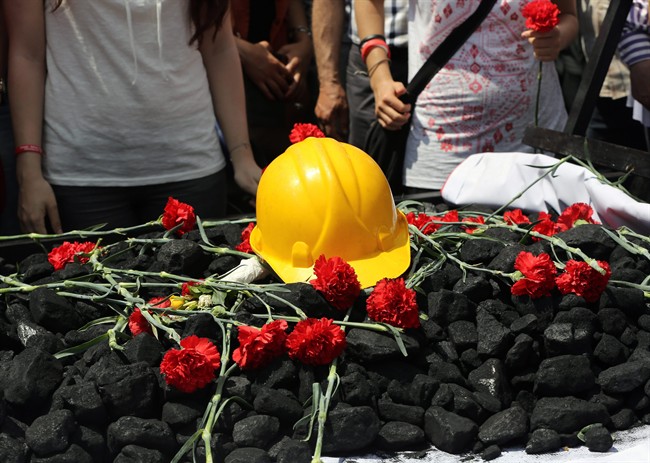 People place flowers on some coal and a hard hat as nearly 2,000 university students called on the government to resign as they marched to commemorate the beginning of the Turkish War of Independence started on May 19, 1919, in Ankara, Turkey, Monday, May 19, 2014. 