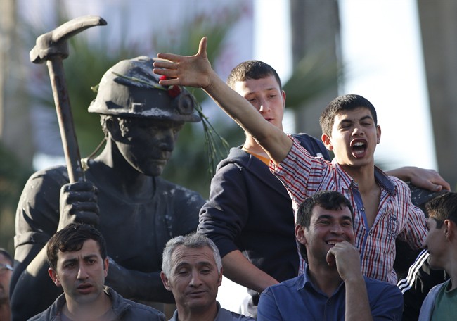 Anti-government protesters chant slogans on a monument for the town's miners, during a march in Soma, Turkey where the mine accident took place, Friday, May 16, 2014.