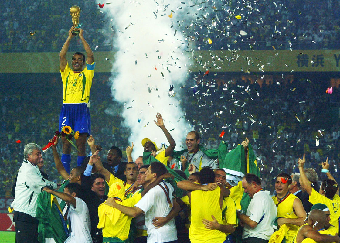 Brazil's team captain and defender Cafu hoists the World Cup trophy over the whole Brazilian team as confetti fall over the pitch during the award ceremony at the International Stadium Yokohama, Japan, 30 June, 2002 following Brazil's 2-0 victory against Germany in match 64 of the 2002 FIFA World Cup Korea Japan final. Brazil has now won a record five World Cup titles. Brazil previously was a FIFA World Cup winner in 1958, 1962, 1970 and 1994. AFP PHOTO ANTONIO SCORZA (Photo credit should read ANTONIO SCORZA/AFP/Getty Images)