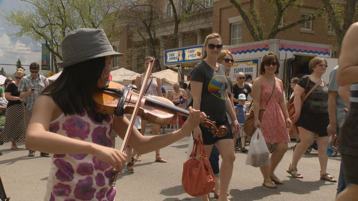 Busker Mariel Tuazon, 12, played the violin at the Cathedral Village Arts Festival Streetfair on Saturday.